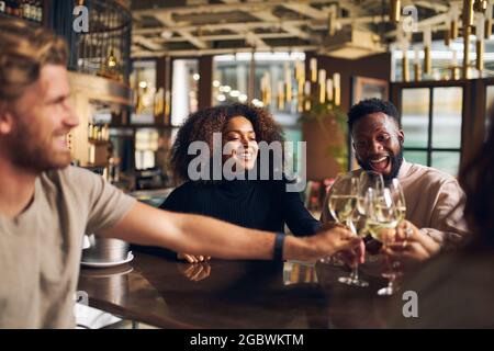 Freunde, die sich in der Weinbar wiedersehen Stockfoto
