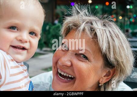 Oma lacht und macht Selfies mit Enkel. Stockfoto
