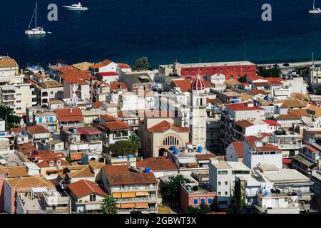 Zakynthos, Griechenland Insel Hauptstadt Panorama mit flachen Gebäuden. Sonniger Blick auf die orthodoxe Kirche um die roten Ziegelhäuser, neben der ruhigen Uferpromenade. Stockfoto