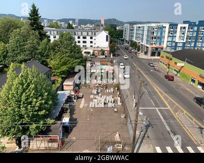 Portland, Oregon, USA. August 2021. East Burnside Street, Blick vom Dach des Lolo Pass. Immer mehr Amerikaner werden auf COVID getestet und warten länger auf Ergebnisse, da Virusfälle ansteigen und Orte von Büros zu Konzertsälen verlangen, dass Menschen beweisen, dass sie nicht infiziert sind. 165 Millionen Amerikaner sind jetzt vollständig geimpft, aber viele von denen, die ihre Schüsse nicht erhalten haben, bleiben skeptisch. Diejenigen, die einen Impfstoff erhalten haben, erkrankten mit weit geringerer Wahrscheinlichkeit an dem Coronavirus als die nicht geimpften. (Bild: © John Marshall Mantel/ZUMA Press Wire) Stockfoto