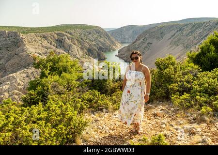 ZADAR, KROATIEN - 10. Jul 2021: Eine Frau, die auf einem Berg mit Blick auf die Schlucht des Flusses Zrmanja steht. Stockfoto