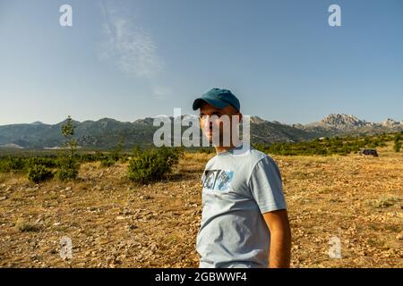 ZADAR, KROATIEN - 10. Jul 2021: Ein Mann, der auf einem Berg mit Blick auf die Schlucht des Flusses Zrmanja steht. Stockfoto