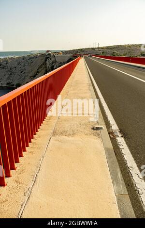 ZADAR, KROATIEN - 10. Jul 2021: Eine rote lange Brücke über den Fluss Zrmanja. Stockfoto