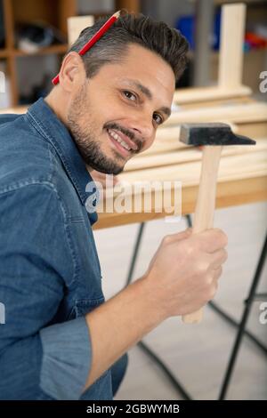 Ein männlicher Zimmermann hagelt einen Nagel Stockfoto