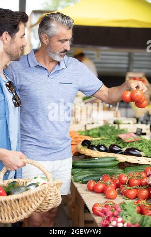 Freunde, die zusammen auf dem lokalen Lebensmittelmarkt einkaufen Stockfoto