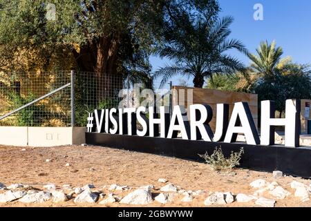 Sharjah, Vereinigte Arabische Emirate, 24.11.2020. Besuchen Sie den Sharjah Hashtag vor dem Museum des Mleiha Archaeological Center mit Palmen. Stockfoto