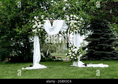 Sehr schöner Hochzeitsbogen des Brautpaten in der Natur Stockfoto