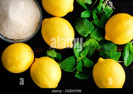 Limonata Türkische Limonade Zutaten auf einem Holzhintergrund: Zitronen, Zucker und Minzblätter auf einem Holztisch Stockfoto