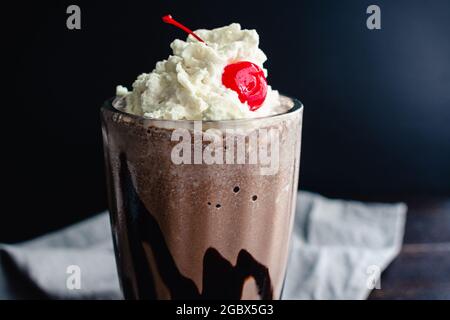 Bourbon Chocolate Milkshake with a Cherry On Top: Ein dunkler Schokoladenmilchshake mit Bourbon-Whiskey mit Schlagsahne Stockfoto