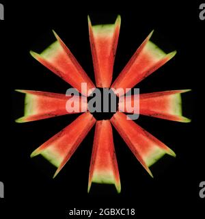 Wassermelone, die in gleiche Teile geschnitten wurde, in Form eines Kreises, auf schwarzem Hintergrund isoliert, Blick von oben Stockfoto