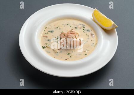 finnische cremige Suppe mit Lachsfisch und Dill auf weißem Teller auf grauem Hintergrund Stockfoto