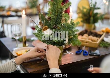 Meisterkurs zum Dekorieren eines Bio-Weihnachtsbaums mit dekorativen Naturelementen und zum Erstellen einer festlichen Komposition. Der Trend zum neuen Jahr ist Null Stockfoto