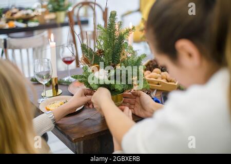 Meisterkurs zum Dekorieren eines Bio-Weihnachtsbaums mit dekorativen Naturelementen und zum Erstellen einer festlichen Komposition. Der Trend zum neuen Jahr ist Null Stockfoto