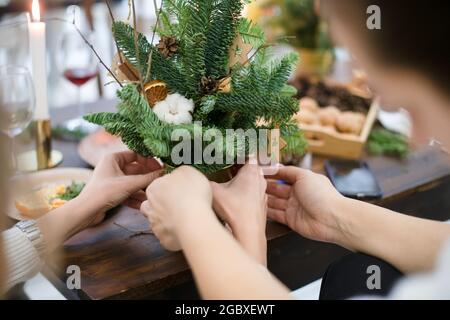 Meisterkurs zum Dekorieren eines Bio-Weihnachtsbaums mit dekorativen Naturelementen und zum Erstellen einer festlichen Komposition. Der Trend zum neuen Jahr ist Null Stockfoto