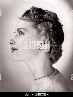 1950ER JAHRE PROFIL PORTRÄT HÜBSCHE FRAU KURZES HAAR CRESCENT GEFORMTER CLIP OHRRING - G3380 CLE003 HARS BERUF B&W BRÜNETTE BERUF PRETTY OHRRING KOPF- UND SCHULTERSTILE KARRIERE CLIP FEMININE BERUFE GEHOBENE CRESCENT-PROFILE WOHLHABENDE NAHAUFNAHME LONE STILVOLLE MODE, DIE GUT ZU TUN IST JUNGE ERWACHSENE FRAU SCHWARZ UND WEISS KAUKASISCHEN ETHNIE ALTMODISCHE KURZE HAARE Stockfoto