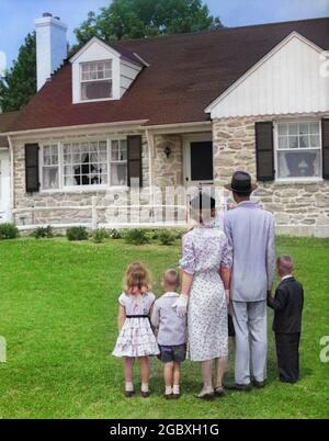 FÜNFKÖPFIGE FAMILIE AUS DEN 1950ER JAHREN MIT RÜCKEN ZUR KAMERA AUF RASEN UND BLICK AUF DAS VORSTADTHAUS AUS FELDSTEIN - J7145C HAR001 HARS-FIGUR JUGEND KLASSISCH ALLEINSTEHEND IM FREIEN DREI HAUSFRAU ALLEIN FRAU RASEN IM FREIEN ZUSAMMEN MANN 3 VERKAUF PAPA STEHEN MUTTER GESCHICHTE AUSSEHEN NOSTALGISCHES PAAR ERSTE STEIN SUBURBAN FARBE BEZIEHUNG MÜTTER EXECUTIVE ALTE ZEIT ZUKUNFT NOSTALGIE BRUDER ANWESEN ALTE MODE SCHWESTER 1 JUVENILE SÖHNE FAMILIEN LIFESTYLE FÜNF ELTERN FRAUEN VERHEIRATET 5 BRÜDER BEZIEHUNG EHEGATTE EHEMÄNNER ZU HAUSE LEBEN MENSCHEN KINDER VOLLZEIT TÖCHTER INSPIRATION KAUFEN MÄNNER GESCHWISTER AMERICANA SCHWESTERN BEGINNEN VÄTER Stockfoto