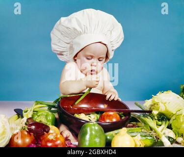 60ER JAHRE BABY TRÄGT WEISSEN KOCH 'S TOQUE HUT HERSTELLUNG EINES FRISCHEN GEMÜSESALAT IN EINER GROSSEN SCHÜSSEL - KB5624 HAR001 HARS PFEFFER STUDIO SHOT HEALTHINESS HOME LIFE COPY SPACE HALF-LENGTH SALAT FRESH HUMORVOLL BERUF WELLNESS KOPF UND SCHULTERN KARRIERE WISSEN FORTSCHRITT KOMISCH PRIDE BERUFE KONZEPTIONELLE KOMÖDIE STILVOLLE TOMATEN WERFEN JUVENILES PAPRIKA TOQUE BABY MÄDCHEN KAUKASISCHEN ETHNIZITÄT CHEF'S KONZENTRATION LEBENSMITTELZUBEREITUNG HAR001 ALT MODISCH Stockfoto