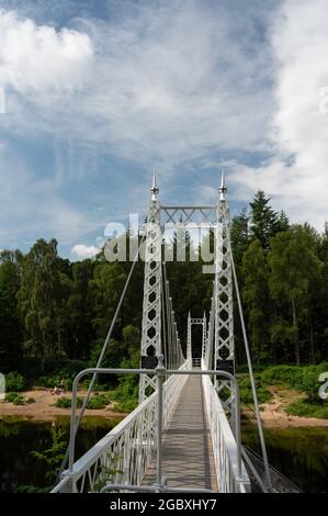 Die weiße Cambus O'May Hängebrücke über den Fluss Dee mit Wald, blauem Himmel und Wolken im Hintergrund. Stockfoto