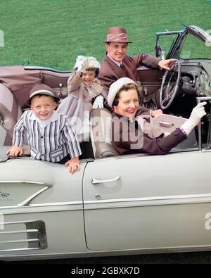 LÄCHELNDES FAMILIENPORTRAIT AUS DEN 1950ER JAHREN MUTTER VATER SOHN TOCHTER IM CHEVROLET CABRIOLET-AUTOMOBIL BEIM BLICK AUF DIE KAMERA - M1139C HAR001 HARS FUN OUTDOOR-AUTOS ZUSAMMEN MANN VATER VIER REISE-FAHRER MUTTER HÜTE NOSTALGISCHE PAAR 4 FARBE BEZIEHUNG MÜTTER KONVERTIERBAR ALTE ZEIT ZAHLEN NOSTALGIE ALTE MODE AUTO 1 JUGENDLICHES FAHRZEUG SÖHNE FAMILIEN LIFESTYLE ERWACHSENE ZUFRIEDENHEIT ELTERN FRAUEN BEZIEHUNG PORTRÄTS EHEMÄNNER ERWACHSENE TRANSPORT KOPIE RAUM HALB-LENGTH TÖCHTER ERWACHSEN-UP AUTOMOBIL MÄNNER TRANSPORT VÄTER MÄNNER UND FRAUEN VÄTERLICHEN BLICKKONTAKT CABRIOS VATERSCHAFT MÜTTERLICHES GLÜCK Stockfoto