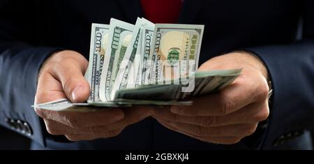 Ein Geschäftsmann, der amerikanische Dollar in den Händen hält. Stockfoto