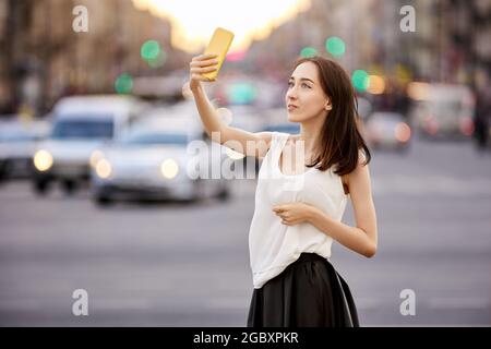 Videobloggerin nutzt Smartphone, um von der Straße in der Stadt zu berichten. Stockfoto