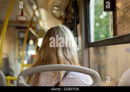 Passagier im Bus. Das Mädchen in öffentlichen Verkehrsmitteln. Das Mädchen sitzt auf einem Sitzplatz im Bus. Stockfoto