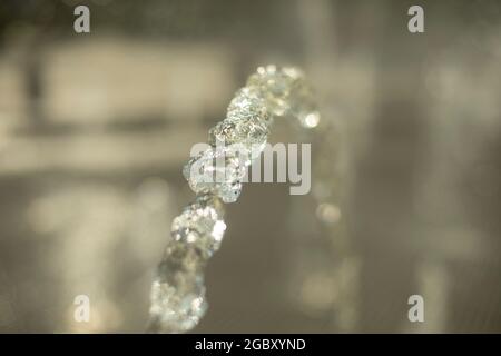 Spritzwasser. Ein Flüssigkeitsstrahl. Wasser in natürlichem Licht. Wasserstrahl. Stockfoto