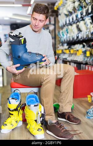 Kundenmann versucht, neue Schuhe zum Skifahren anzuprobieren Stockfoto
