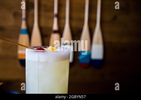 Eine Hand mit einem Whisky-Cocktail aus Orange, serviert in einer Außenbar in Bodega Bay, Kalifornien Stockfoto