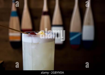 Eine Hand mit einem Whisky-Cocktail aus Orange, serviert in einer Außenbar in Bodega Bay, Kalifornien Stockfoto