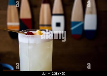 Eine Hand mit einem Whisky-Cocktail aus Orange, serviert in einer Außenbar in Bodega Bay, Kalifornien Stockfoto