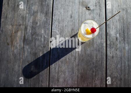 Eine Hand mit einem Whisky-Cocktail aus Orange, serviert in einer Außenbar in Bodega Bay, Kalifornien Stockfoto