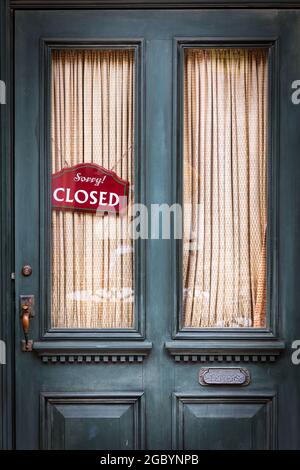 Ein geschlossenes Schild hängt an einem alten Retro-Türfenster in Osaka, Japan. Stockfoto