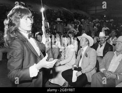 Austin, Texas, USA, um 1987: Auktionator Assistant zeigt Artikel für Gebote bei Fundraiser während der jährlichen Travis County Livestock Show. ©Bob Daemmrich Stockfoto