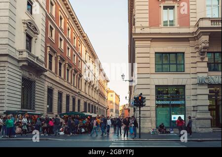 Alte, klassische Gebäude und Menschen, die die Straße der Via delle Muratte entlang gehen, von der Kreuzung mit der Straße der Via del Corso in Rom, Italien, aus gesehen Stockfoto