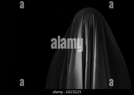 Verschwommener Fokus von weißem Ghost Sheet auf schwarzem Hintergrund für Halloween Festival Gruselkonzept. Stockfoto