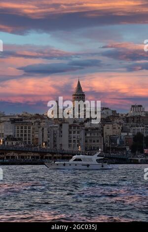 Stadtbild eines Teils der Stadt Istanbul mit Häusern und dem Galata-Turm bei Sonnenuntergang am Hafen von Eminönü. Stockfoto