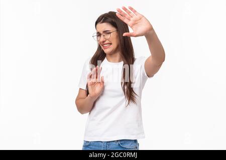 Nein, bitte verletzt mich nicht. Portrait von widerstrebenden und unstrebten, jungen angewiderten Frau, die Hände in der Verteidigung ziehen, versuchen, sich zu schützen und Schritt zurück Stockfoto