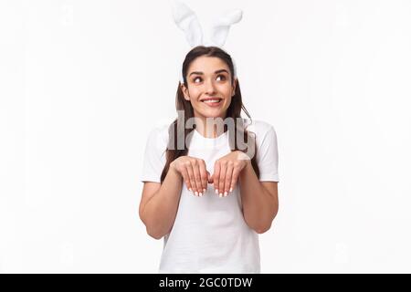 Portrait von lustigen, schönen europäischen Mädchen mit Kaninchenohren, imitieren Hase, Hände wie Pfoten und Blick nach oben Tagträumen, Bildgebung etwas niedlich Stockfoto