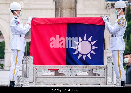 Taipeh, Taiwan. August 2021. Taiwanesische Ehrenwachen falten während einer Flaggensenkungszeremonie in Taipei eine Flagge Taiwans. Kredit: SOPA Images Limited/Alamy Live Nachrichten Stockfoto