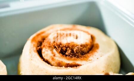 Ungebackene Zimtbrötchen in einer blauen Backform. Stockfoto