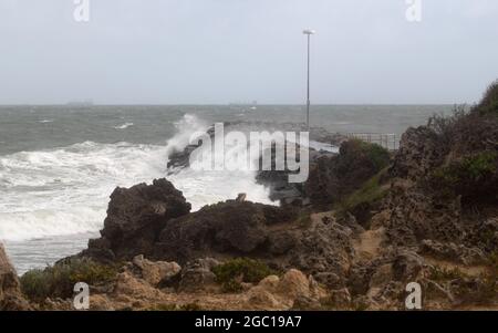 Stürmisches Meer, das über einem Felsgroyne bricht Stockfoto