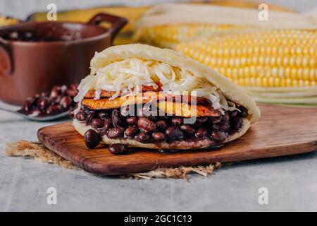 Typische venezolanische Arepa, hergestellt aus gebratenem Kochbananen, schwarzen Bohnen und Käse Stockfoto