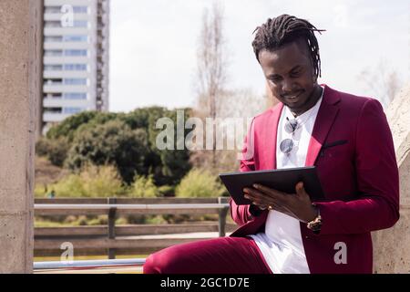 afrikanischer Geschäftsmann tippt auf einem Tablet im Freien in der Stadt, Technologie und Remote-Work-Konzept, kopieren Raum für Text Stockfoto