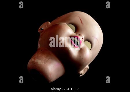 Eindringlich aussehender gebrochener Puppenkopf Stockfoto