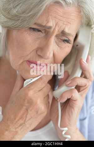 Portrait von traurige ältere Frau am Telefon sprechen Stockfoto