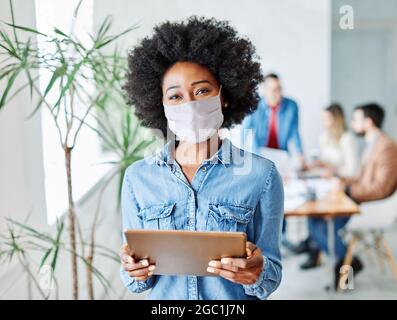 Business Geschäftsfrau Führer exekutiv Sitzung Büro Tablet lächelnd Porträt Virus Maske Schutz Corona Stockfoto