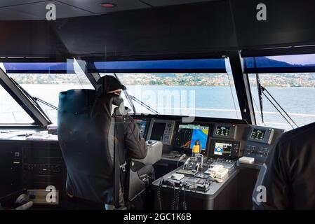 Der Kapitän auf der Schiffsbrücke der Mona Roma-Doppelhullfähre MR-1 steuert in Richtung MONA auf dem Derwent River in Hobart, Tasmanien, Australien Stockfoto