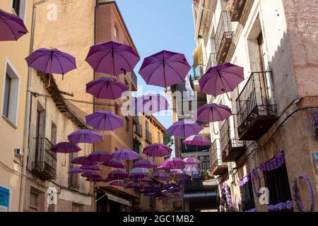 BRIHUEGA, SPANIEN - 10. JULI 2021: Lavendelfarbene Regenschirme auf der Straße während der blühenden Felder, Brihuega, Guadalajara, Castilla-La Mancha, Spa Stockfoto