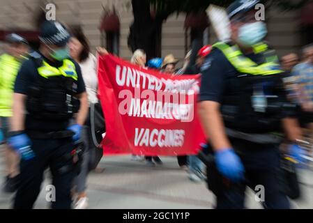 Die Demonstranten halten ein Transparent mit ‘der Aufschrift „united against mandatory Vaccines“ hoch, das während der weltweiten Demonstration für Freiheit in Melbourne am 20. März 2021 in Flagstaff Gardens, Melbourne, Australien, zu sehen ist. In mehr als 40 Ländern der Welt werden Demonstrationen abgehalten, um die Grundrechte zurückzufordern und sich gegen übermäßige COVID-19-Beschränkungen zu wehren. Kredit: Mikko Robles/Geschwindigkeit Medien/Alamy Live Nachrichten Stockfoto